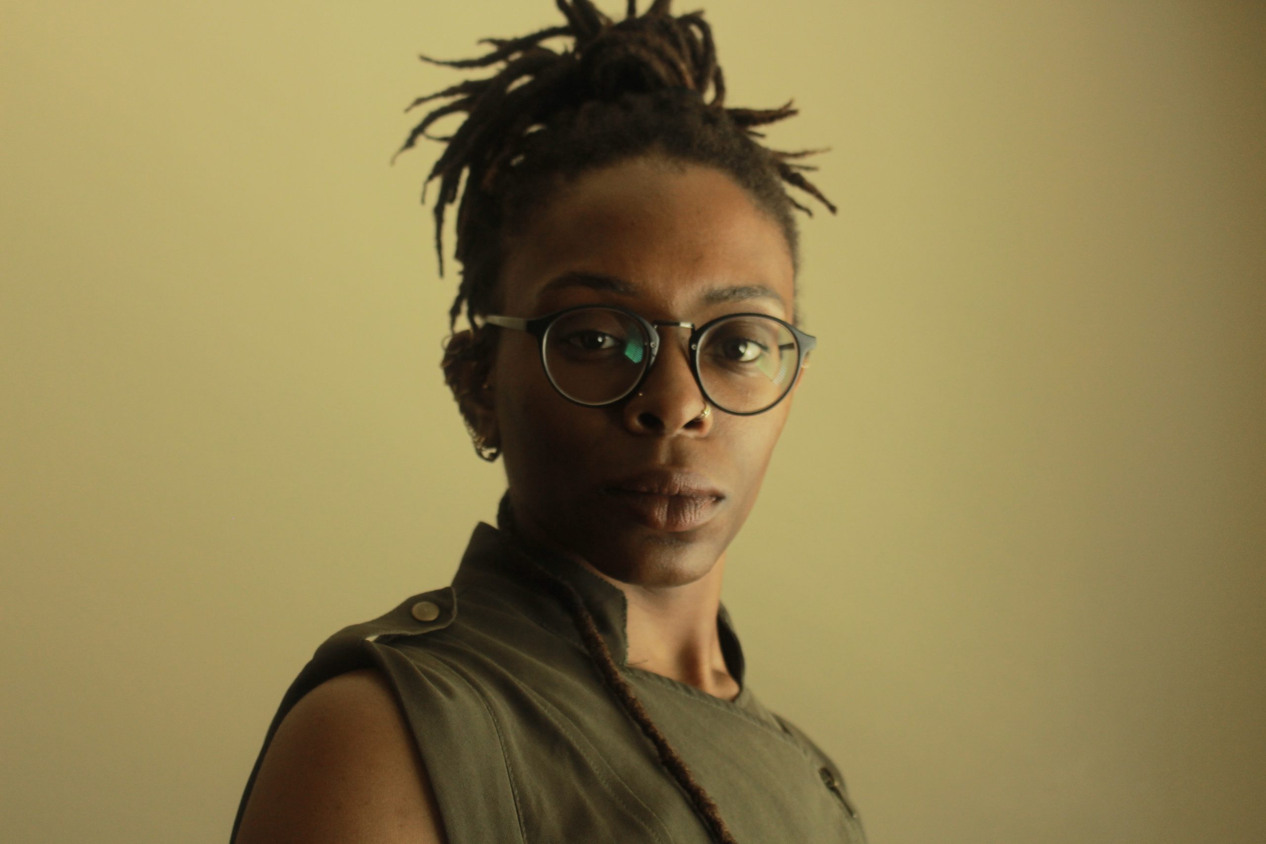 headshot of Chinwe Oniah, a black woman indoors in front of a solid olive backdrop