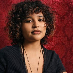 headshot of Angie Morales, Afro-Latinx woman with curly hair